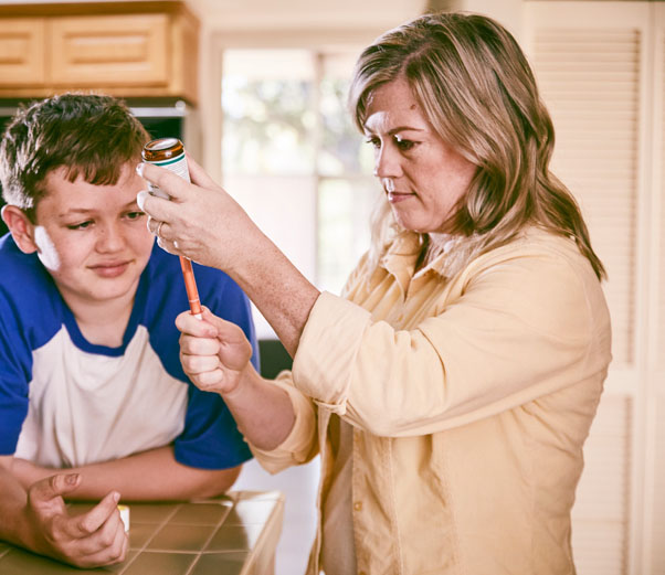 Boy Looking at Medicine Bottle
