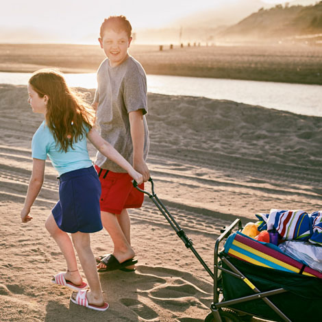 Boy and Girl on Beach Pulling Wagon
