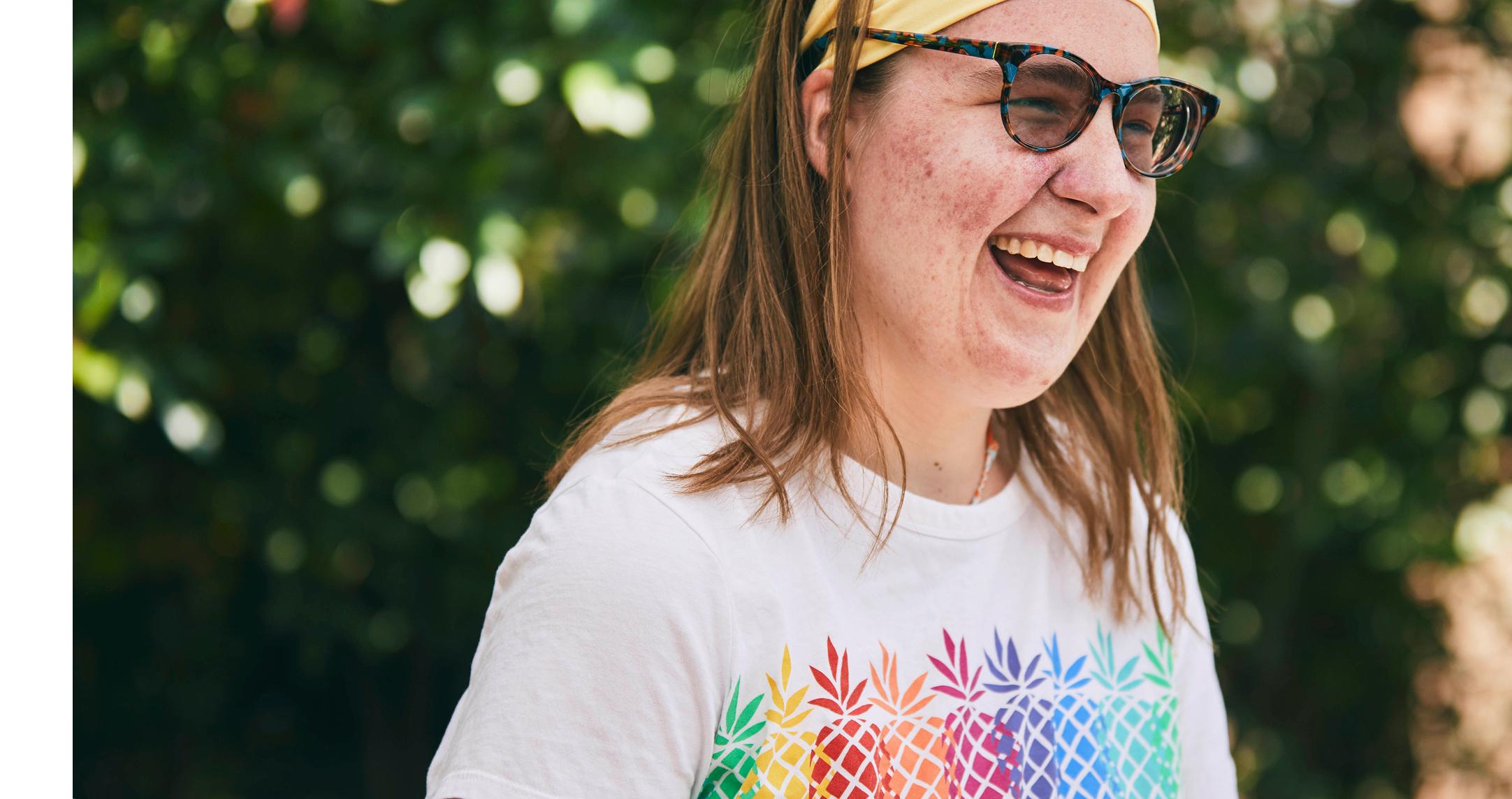 A young lady smiling in a tree-lined setting