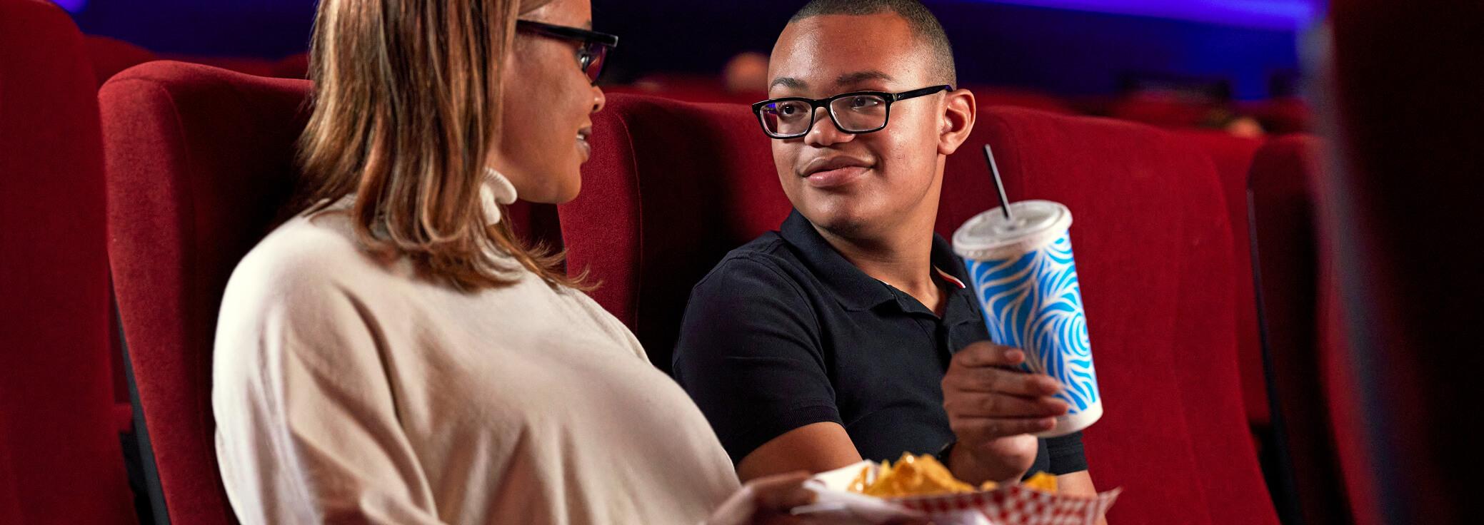 Corey, living with LGS, teenager boy sitting with mother in a movie theatre